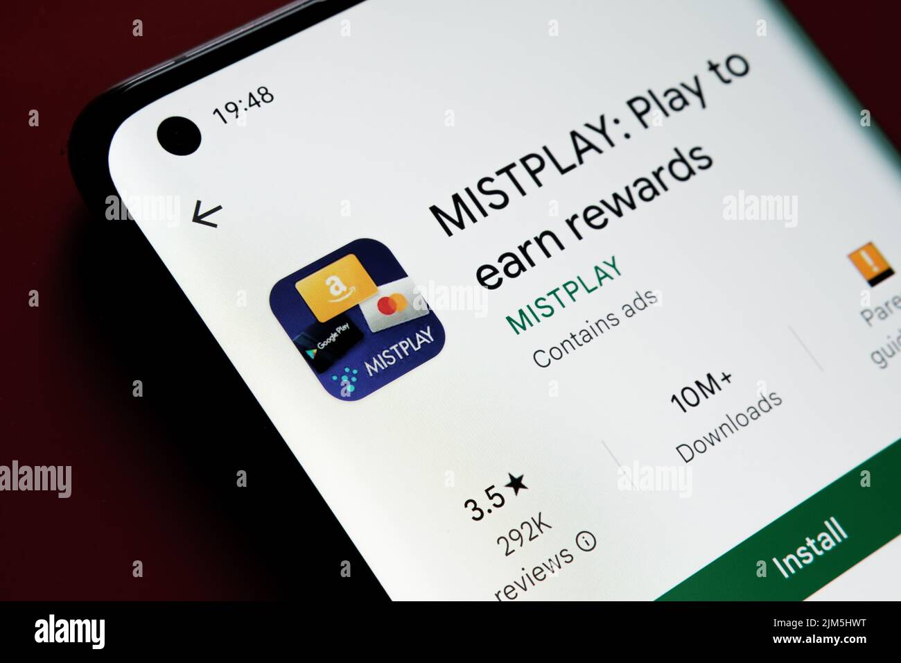 App MISTPLAY visualizzata in Google Play Store sullo schermo dello smartphone su sfondo rosso. Foto ravvicinata con messa a fuoco selettiva. Stafford, Regno Unito Foto Stock