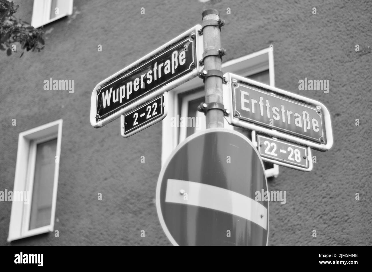 Un'immagine in scala di grigi con le indicazioni stradali che indicano l'incrocio tra le strade Wupperstrasse ed Erftstrasse Foto Stock
