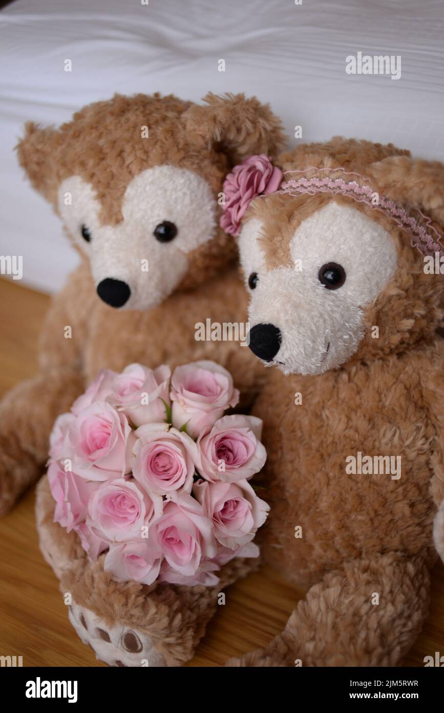 Un primo piano di giocattoli da porta ragazza e ragazzo con un bouquet di rose rosa Foto Stock