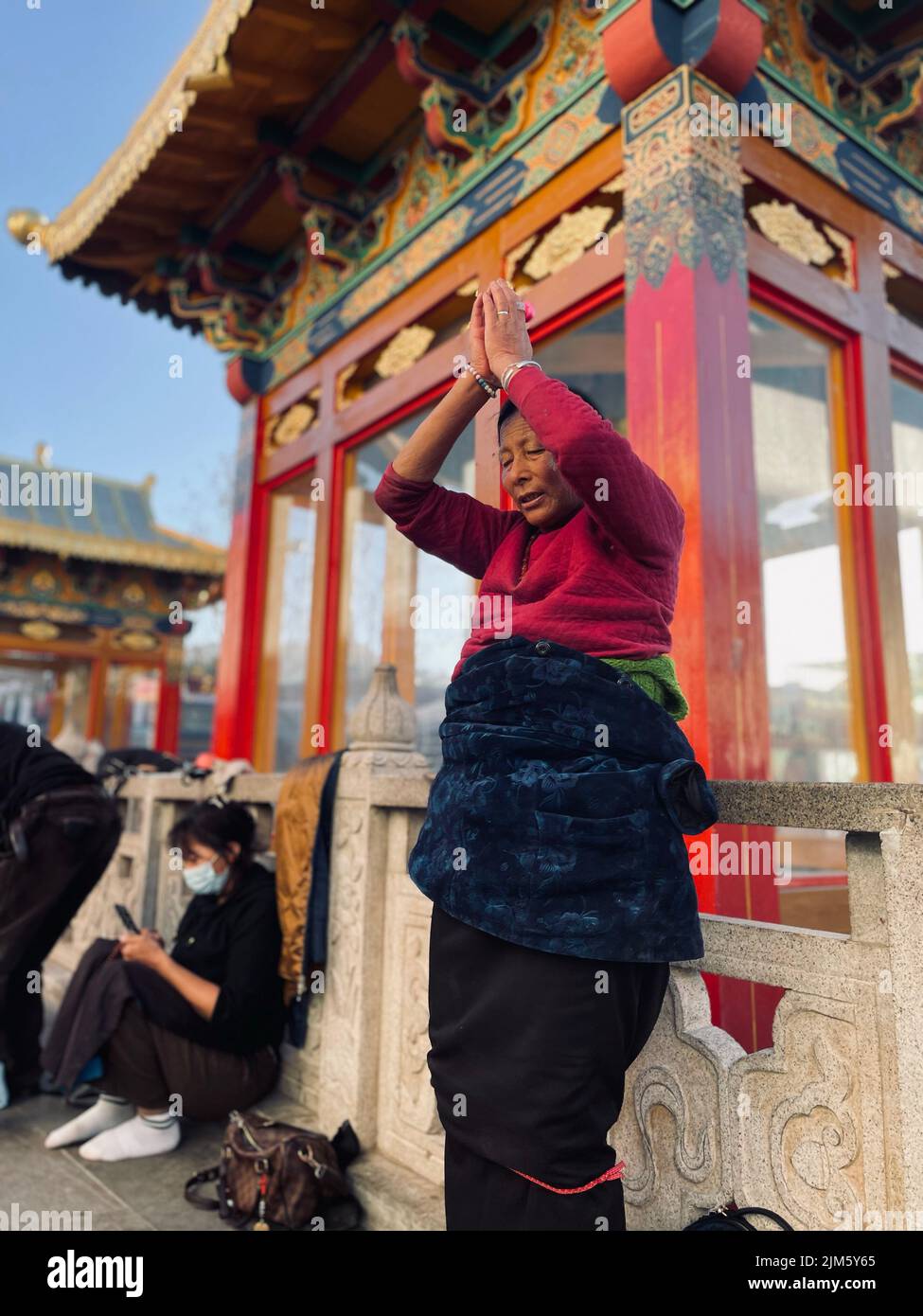 Una donna asiatica di fronte ad un edificio tradizionale nella città di Lhasa in Tibet, Cina Foto Stock