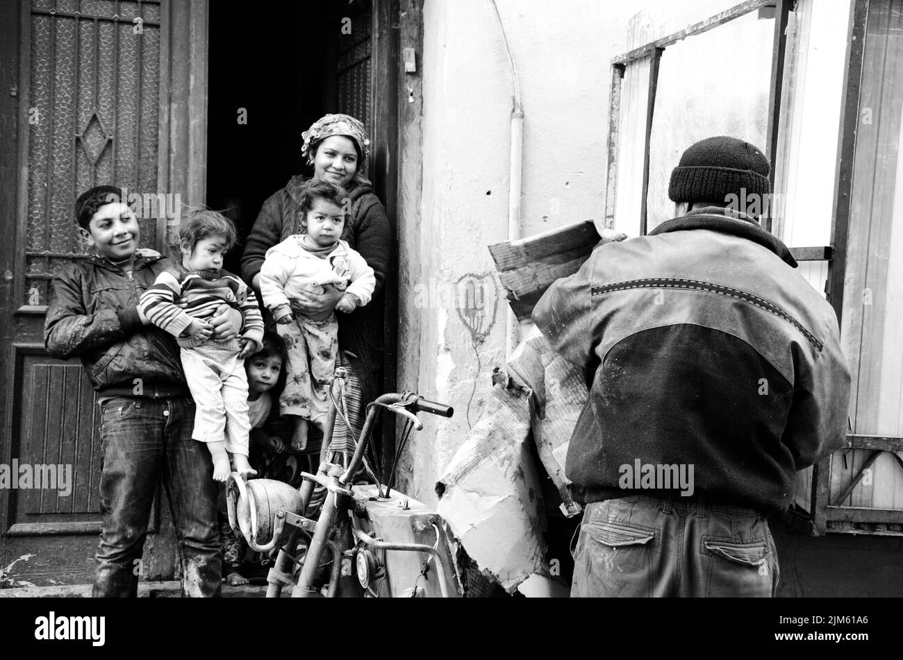 Una foto in scala di grigi di una famiglia di fronte al loro edificio a Istanbul, Turchia Foto Stock