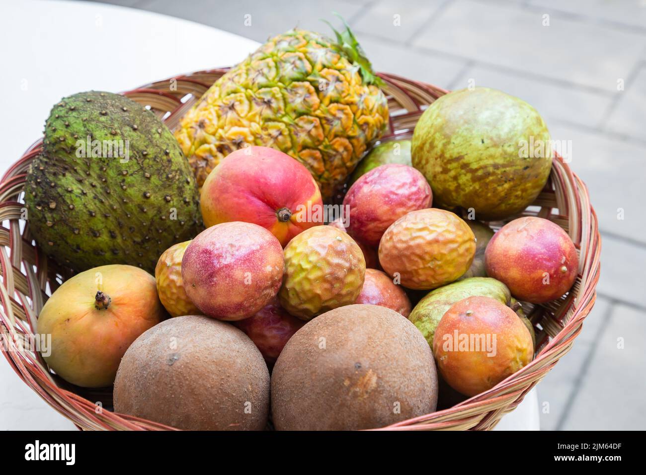 Guardando verso il basso un grande cestino riempito con una varietà di frutta tropicale. Foto Stock