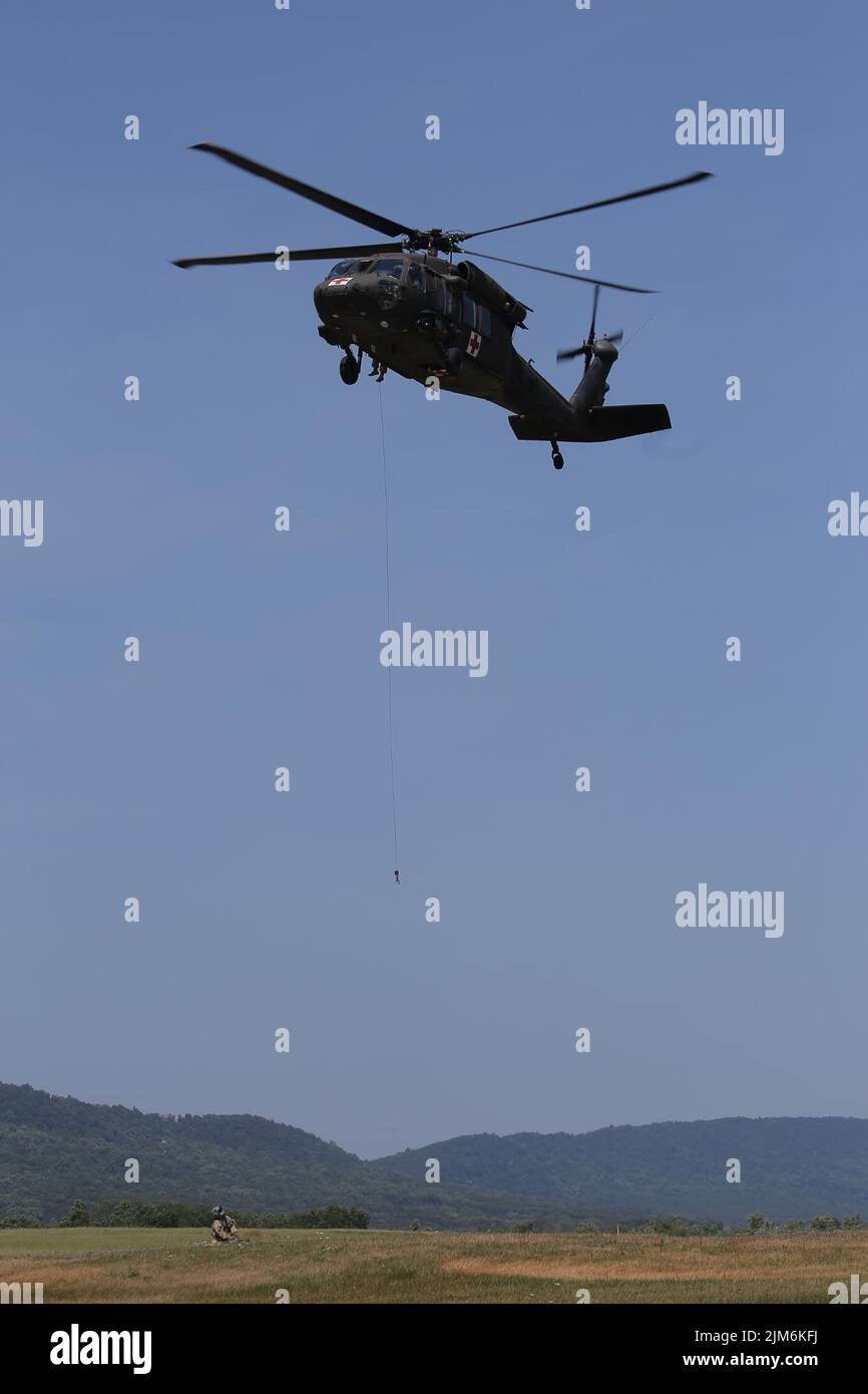 Soldati statunitensi con il treno Expeditionary Combat Aviation Brigade del 28th con un paranco su un elicottero UH-60 Black Hawk come parte di un intervento di emergenza e di un'esercitazione salvavita presso l'aeroporto Muir Army Airfield. (STATI UNITI Foto dell'esercito dello staff Sgt. Eric Smith) Foto Stock