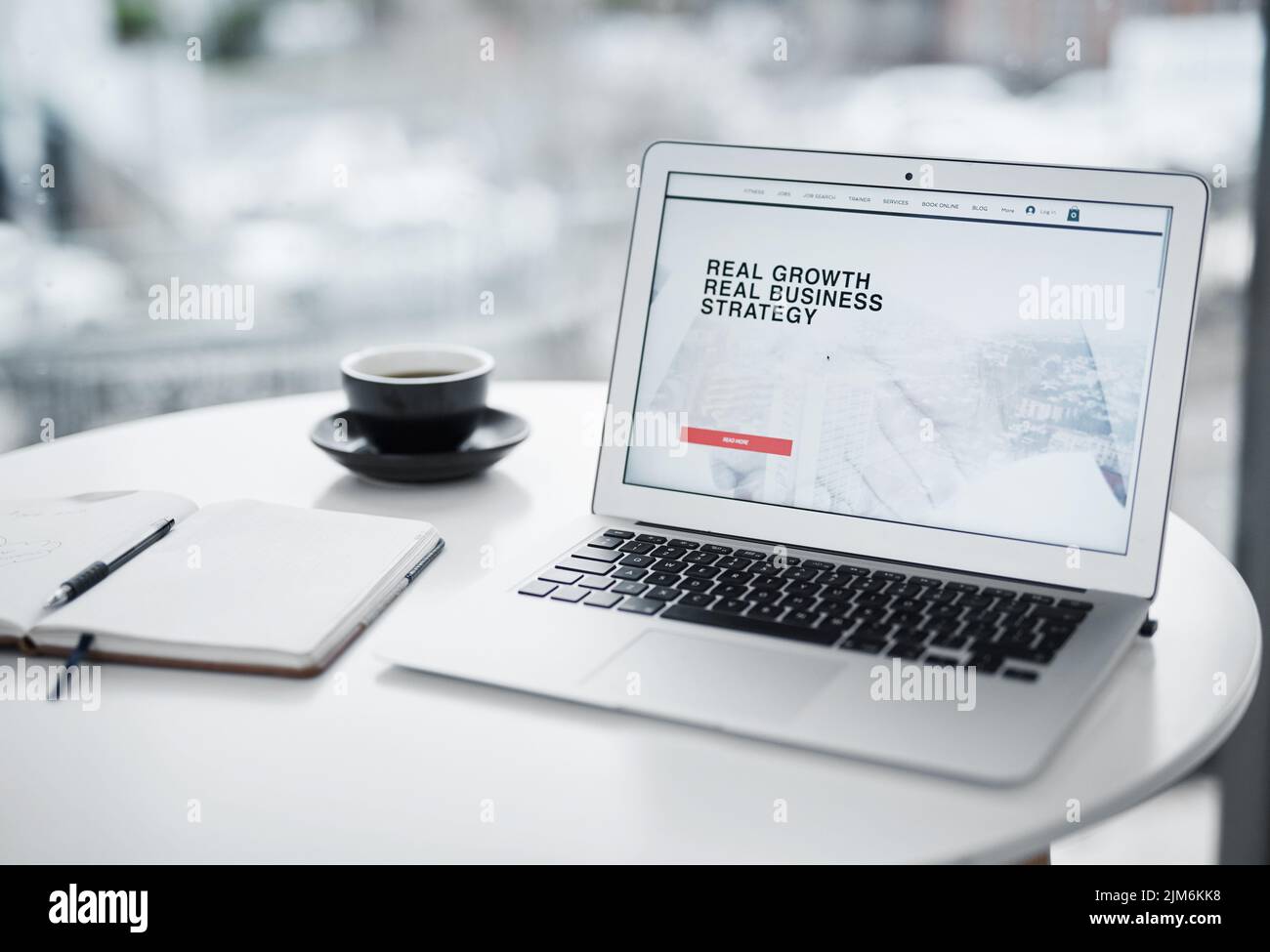Il momento di crescere è ora: Un notebook che visualizza un sito Web aziendale su un tavolo a casa. Foto Stock