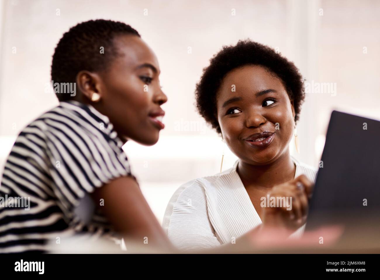 Passare dalla definizione del problema all'implementazione della soluzione. Due donne d'affari che lavorano insieme su un laptop in un ufficio. Foto Stock