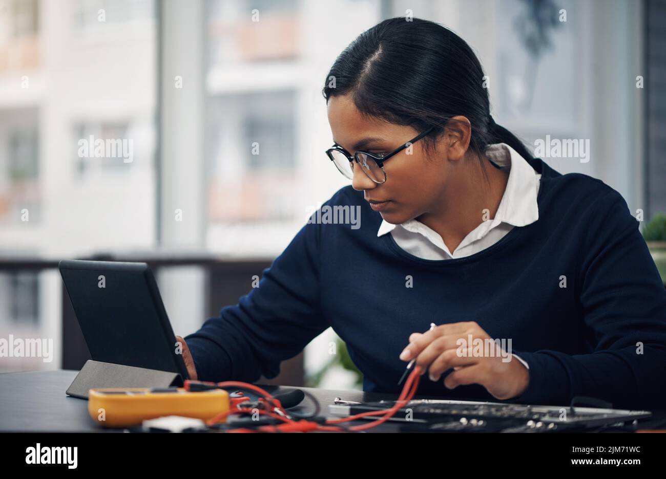 La migliore tecnologia per riparare qualsiasi tecnologia. Un giovane tecnico che utilizza un tablet digitale durante la riparazione dell'hardware del computer. Foto Stock