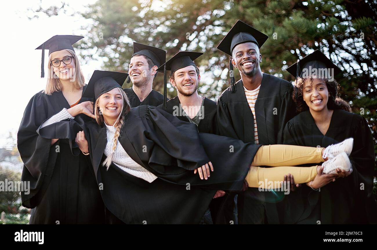 Erano pronti per qualsiasi cosa venga dopo. Ritratto di un gruppo di studenti che tiene uno dei loro coetanei il giorno della laurea. Foto Stock