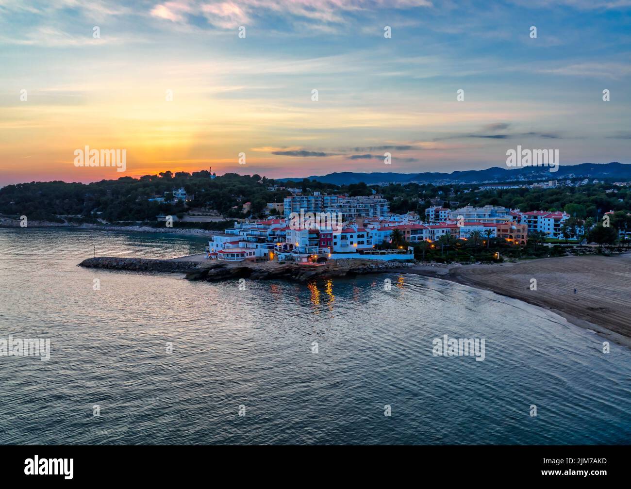 Vista aerea di un tranquillo villaggio sul mare situato in una splendida vista sul mare al tramonto (El Roc de Sant Gaieta, Tarragona, Spagna) Foto Stock