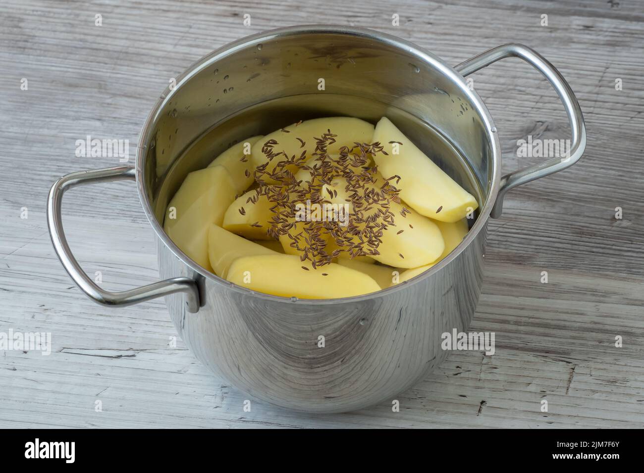 Le patate sbucciate crude in una pentola d'acqua prima della cottura Foto Stock