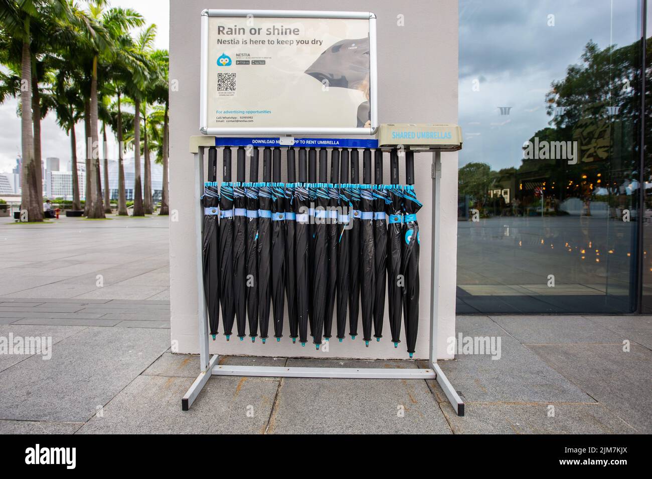 Rack di colori nero e blu ombrello condivisione servizio di business per ripararvi dal tempo bruciante o la stagione piovosa ogni volta che uno ha bisogno di esso. Foto Stock