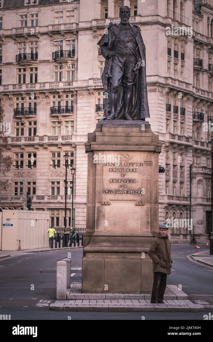 Un colpo verticale di un uomo in piedi vicino al monumento a Londra Foto Stock