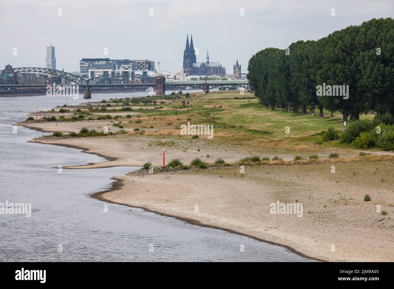 Acque basse del fiume Reno, 25 luglio 2022, rive del fiume Reno a Colonia-poll, vista sul porto Rheinau e la cattedrale, Colonia, Germania. Foto Stock