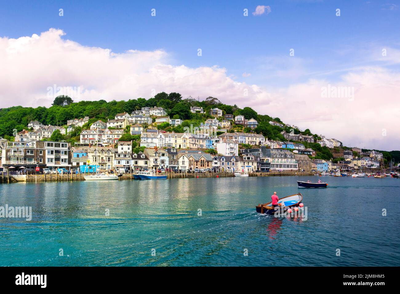 6 giugno 2018: Looe, Cornovaglia, Regno Unito - la piccola città costiera di Looe, con il fiume Looe e case collinari. Barca che attraversa il porto. Foto Stock