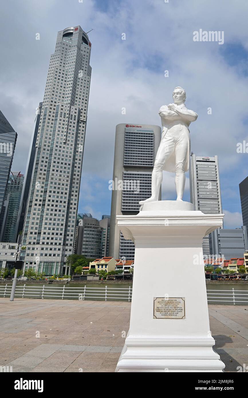 Monumento in marmo bianco di Sir Stamford Raffles, fondatore della Singapore moderna, presso lo storico approdo, con il quartiere finanziario sullo sfondo Foto Stock