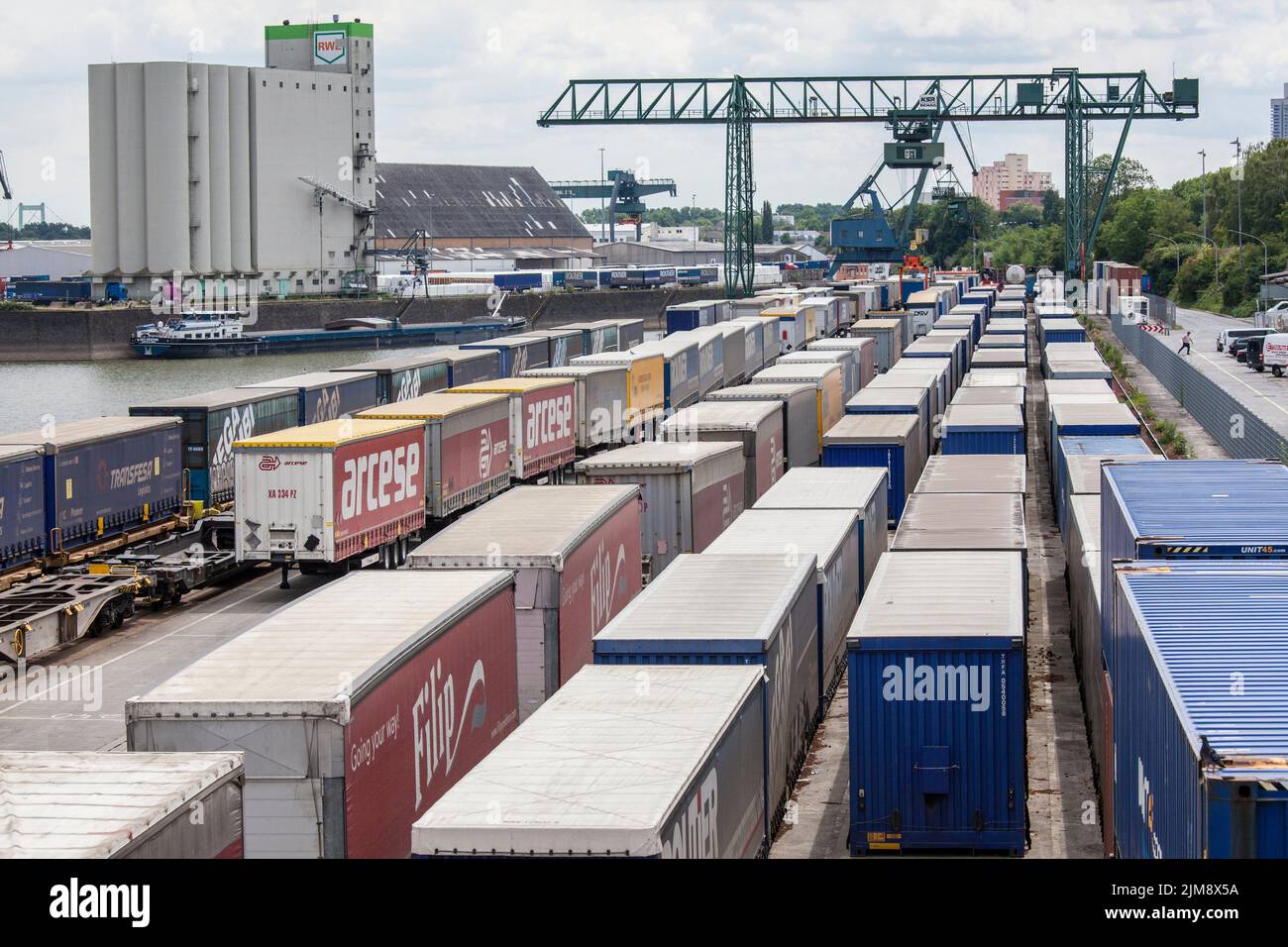 Una gru a portale presso il terminal dei container nel porto del Reno Niehl, i semirimorchi per camion sono pronti per il carico sui treni merci, Colonia, Germania. Porta Foto Stock