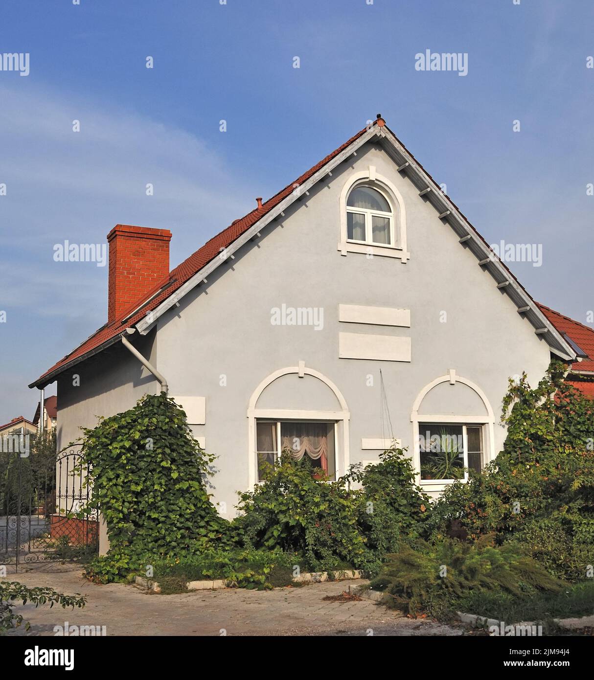 Bella casa di campagna grigia con verdure di fronte Foto Stock