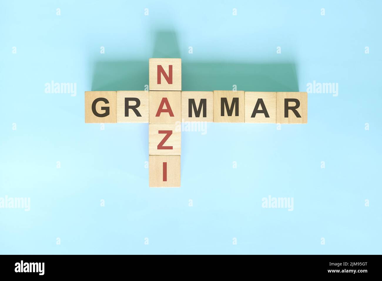 Grammatica nazista concetto. Blocco di legno Crossword puzzle piatto adagiare su sfondo blu. Foto Stock