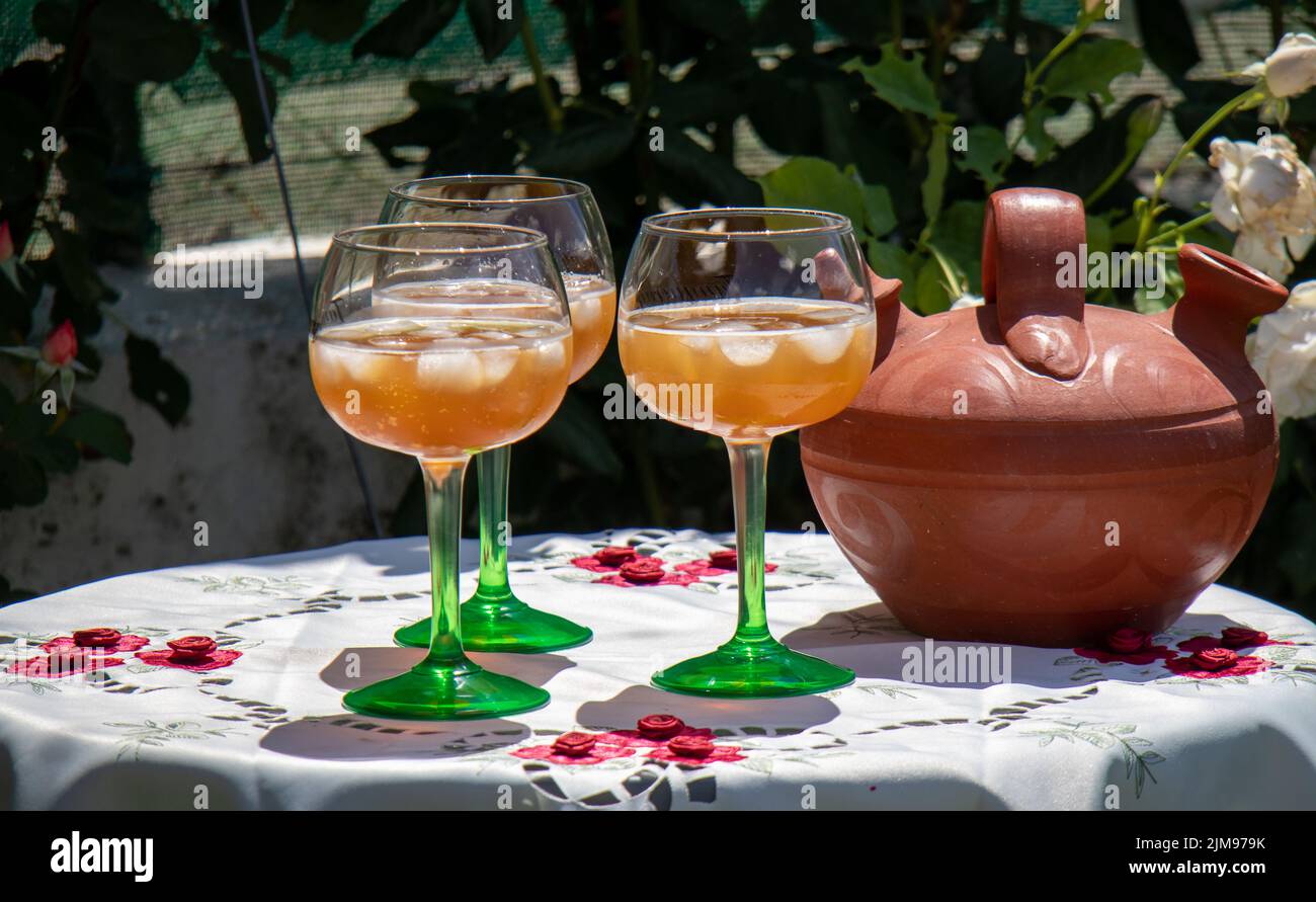 Copas con vermut y hielo en un caluroso día de verano sobre una mesa con mantel bordado y una jarra Foto Stock