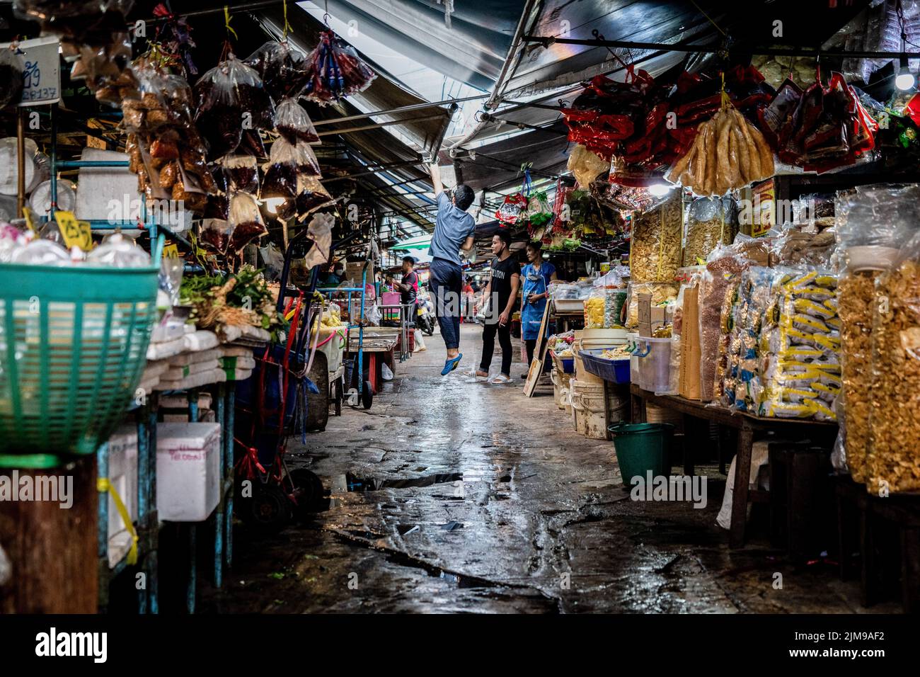 Bangkok, Tailandia. 05th ago 2022. Un fornitore salta per riparare una perdita nel tetto durante le piogge pesanti al mercato umido di Khlong Toey a Bangkok. Vita quotidiana intorno al mercato umido Khlong Toey a Bangkok. Mentre il turismo continua a crescere con l'arrivo di 3 milioni di turisti internazionali quest'anno, il tasso di inflazione al dettaglio della Thailandia è aumentato del 7,66% da un anno fa, portandolo ad un livello massimo di 14 anni e portando alla speculazione che la banca centrale aumenterà il tasso di interesse nell'agosto 2022. Credit: SOPA Images Limited/Alamy Live News Foto Stock