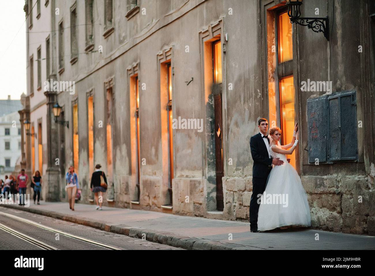 Coppia di nozze in amore per le strade di sera Lviv, Ucraina Foto Stock