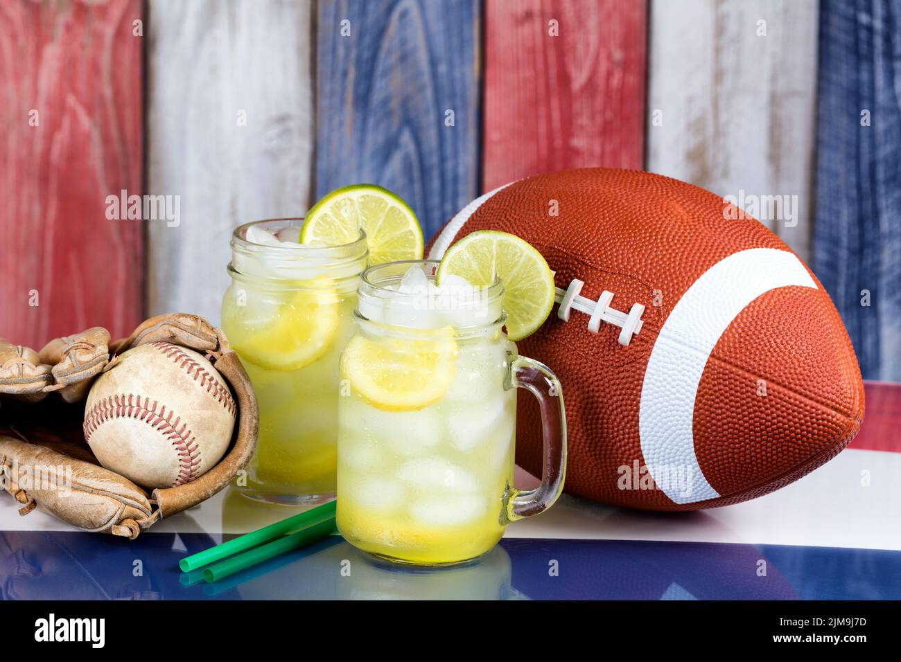 Vasetti di vetro riempiti di limonata fredda con oggetti sportivi sui colori nazionali degli Stati Uniti per la stagione delle festività Foto Stock
