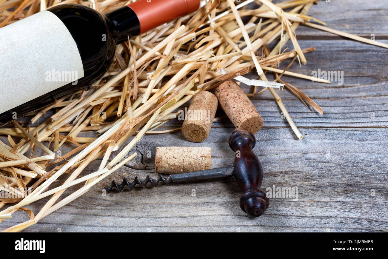 Cavatappi vintage con bottiglia di vino su fondo paglierino Foto Stock