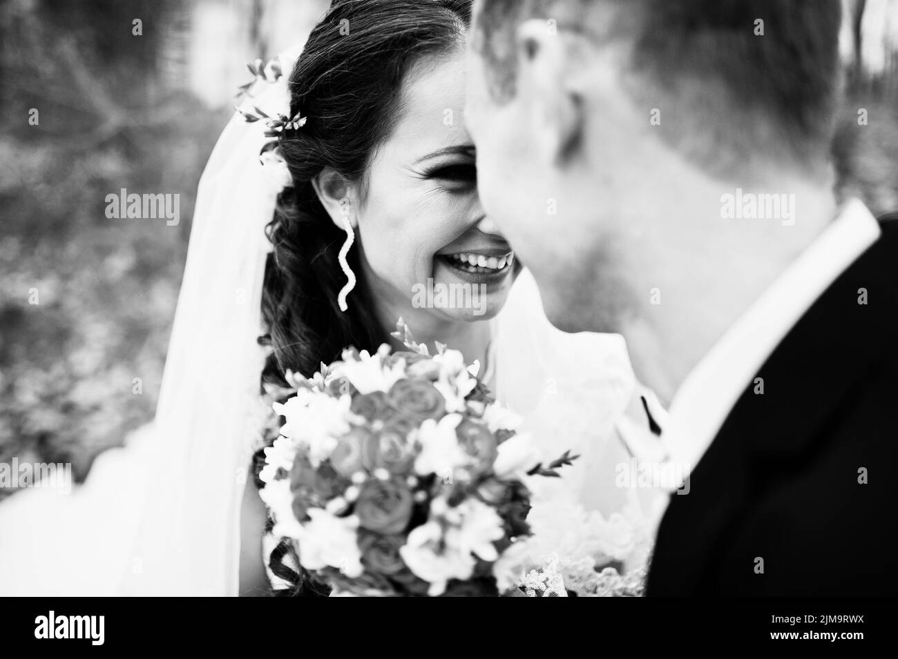 Molto vicino fino look della sposa e lo sposo con piccoli arancio bouquet di nozze Foto Stock
