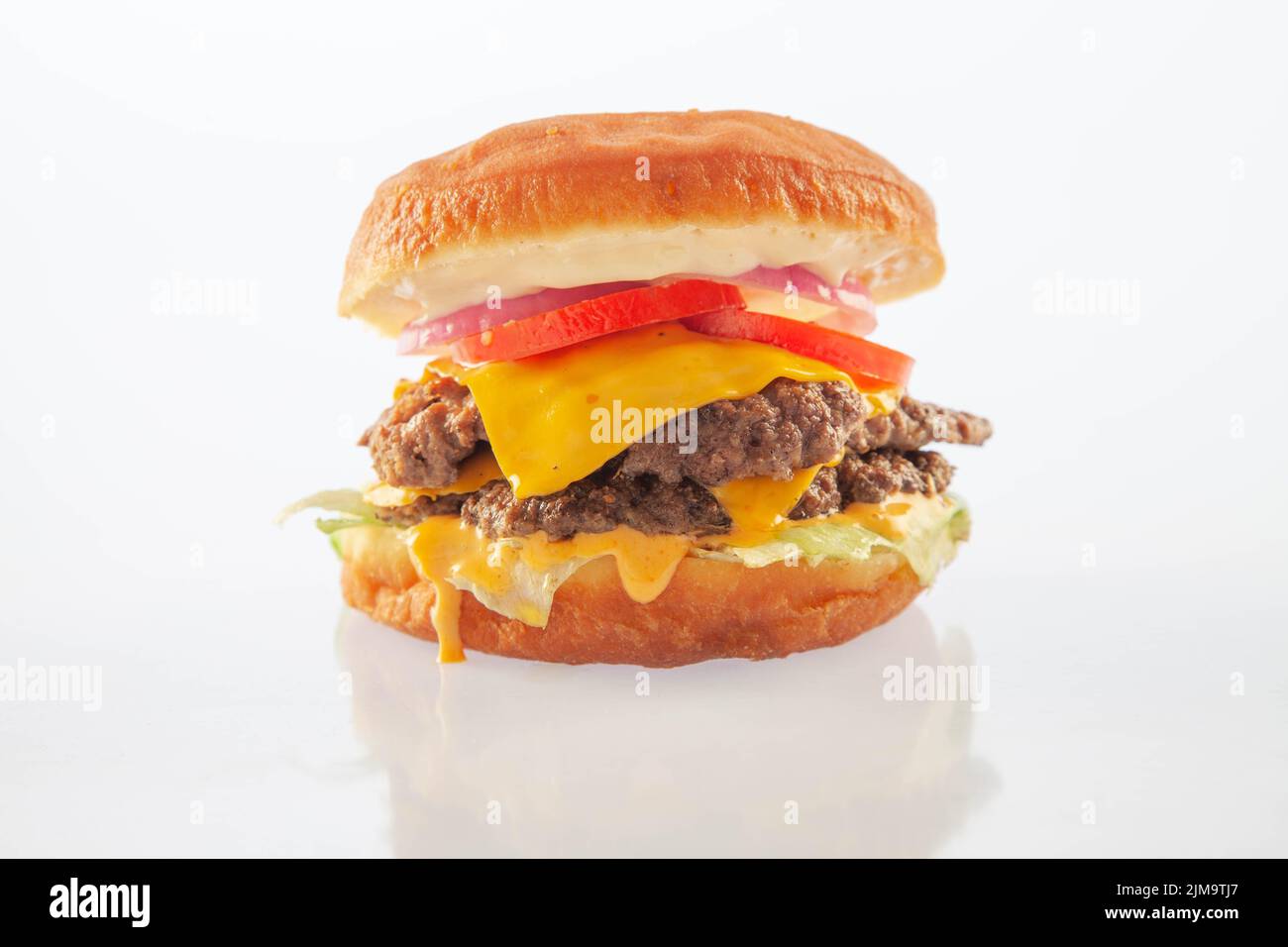 Cheeseburger brioche a due piani con pomodori al formaggio e cipolla. Foto Stock