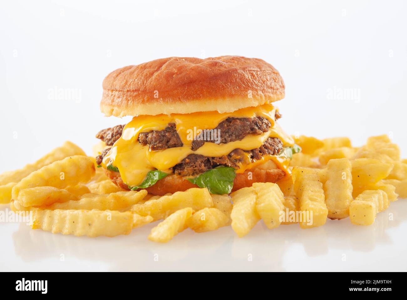 Brioche donut doppio hamburger di formaggio di manzo con salsa di queso e foglie di razzo. Foto Stock