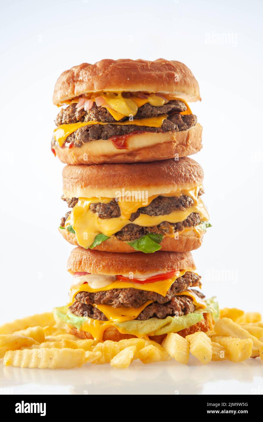 Hamburger brioche da ciambella da buongustai accatastati l'uno sull'altro con patatine fritte. Foto Stock