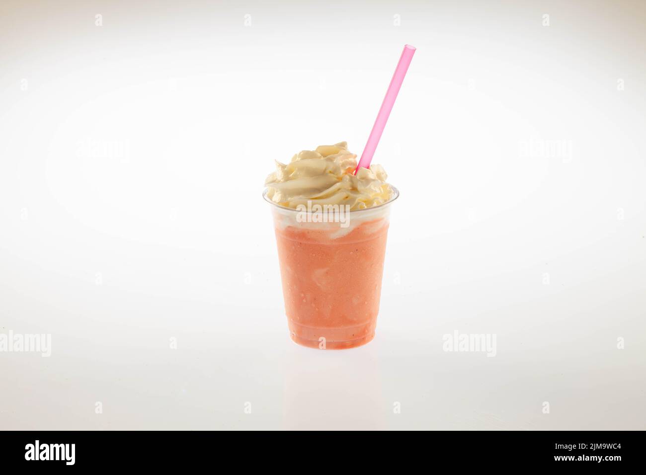 Gelato alla fragola agitare con panna montata sopra e paglia. Foto Stock