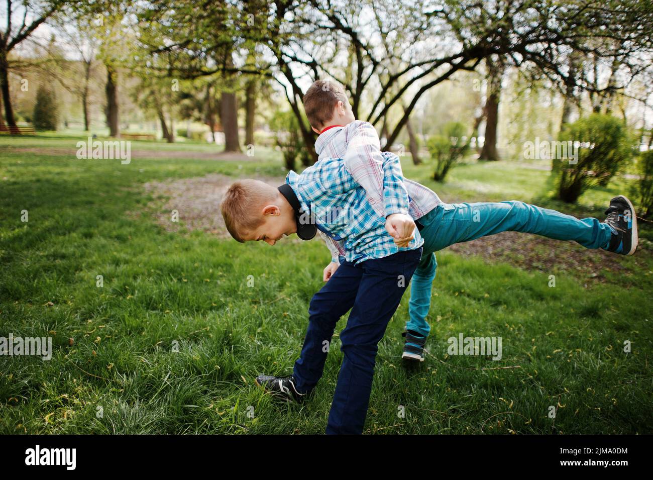 Due fratelli boy con cuffie divertirsi sul parco. Fratello di Amore. Foto Stock