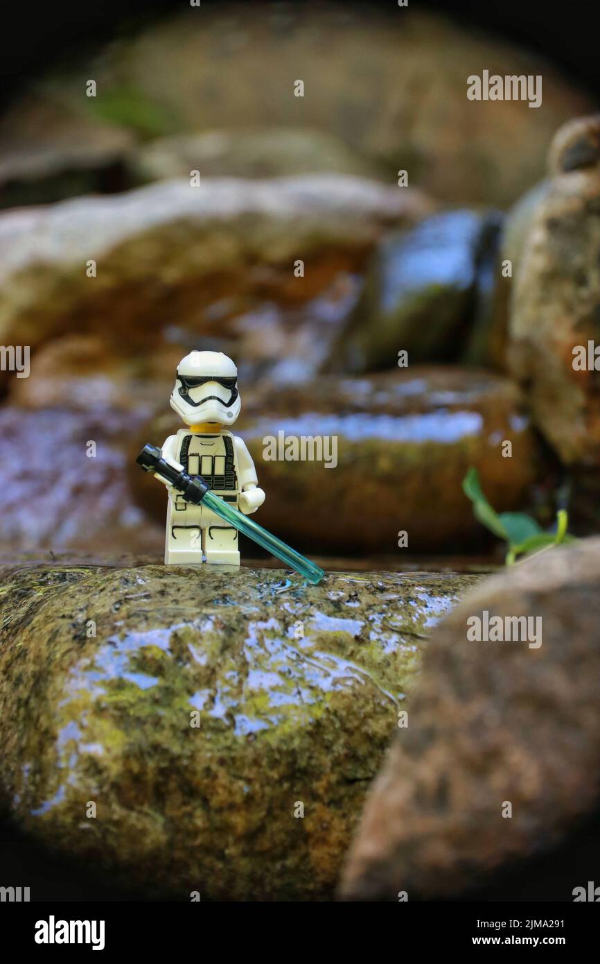Il personaggio giocattolo del lego della trouoper che si erge sulla roccia bagnata, tenendo la spada Foto Stock