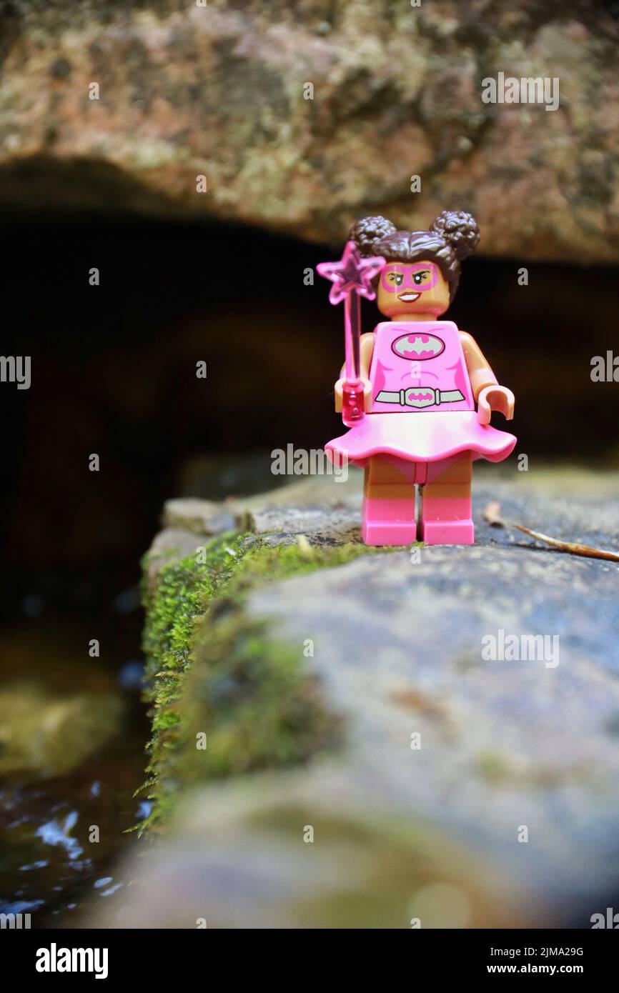 La figura eroica femminile giocattolo in piedi su una roccia che regge una stella bacchetta Foto Stock