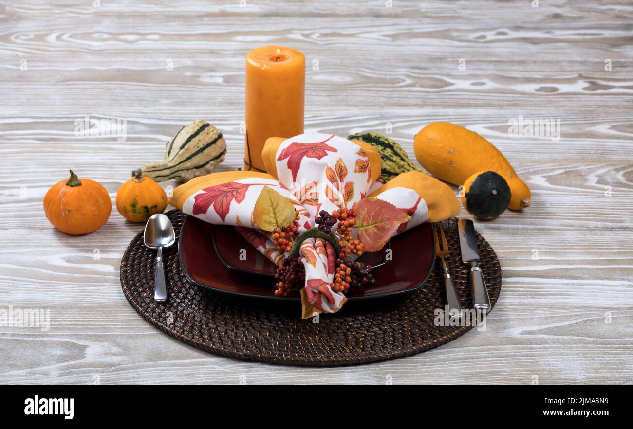 Cena con decorazioni in zucca e candela in legno bianco invecchiato Foto Stock