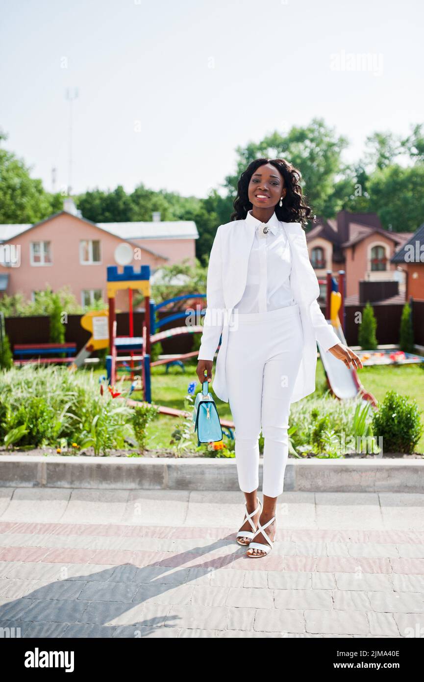 Felice African American Girl in abito bianco in città parco giochi di sfondo Foto Stock