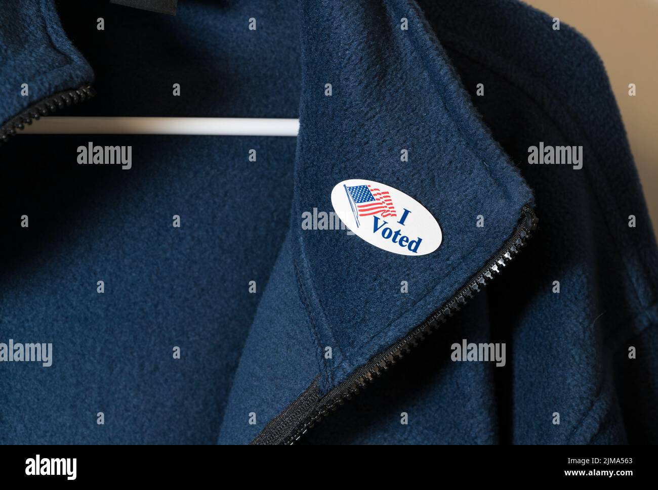 Ho votato l'adesivo sulla giacca blu appesa sull'appendiabiti Foto Stock