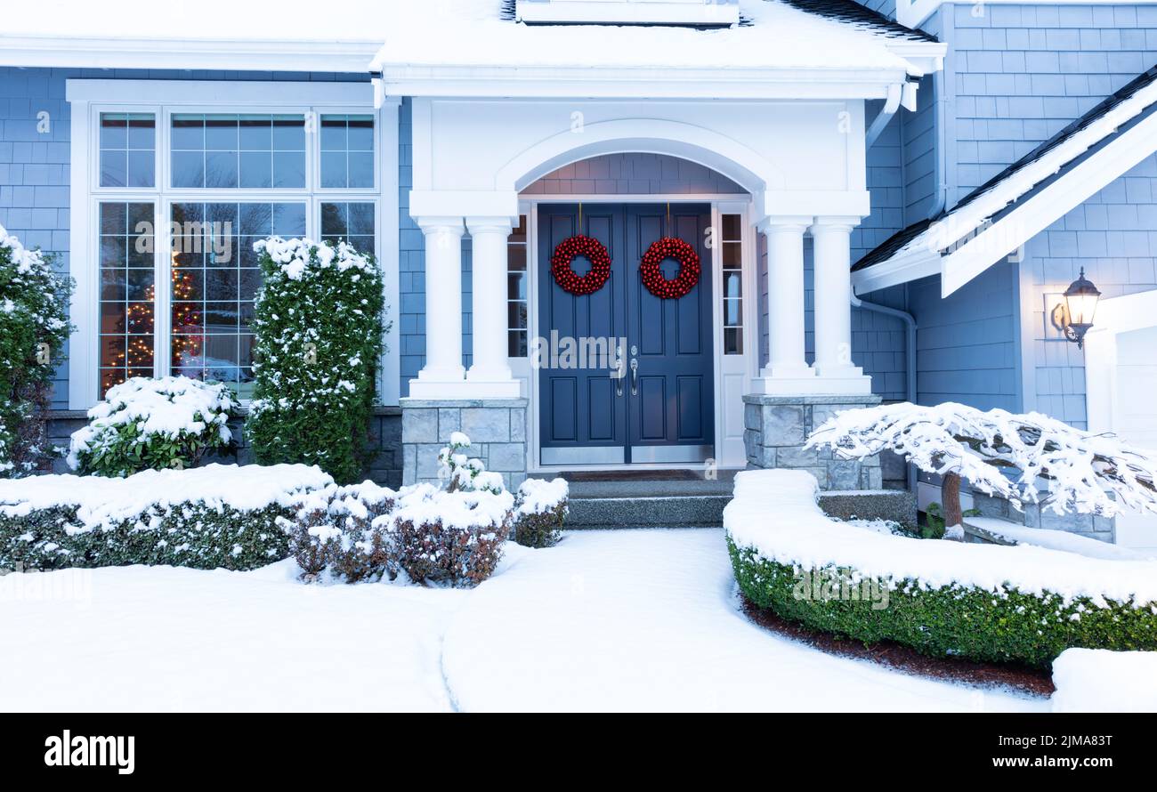 Passerella a casa decorata per le vacanze invernali con neve fresca Foto Stock