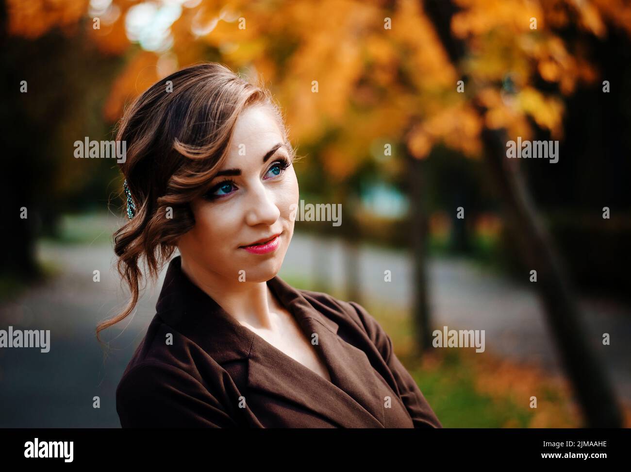 Close up volto ritratto di ragazza intelligente con un vecchio stile acconciatura outdoor in marrone cappotto. Foto Stock