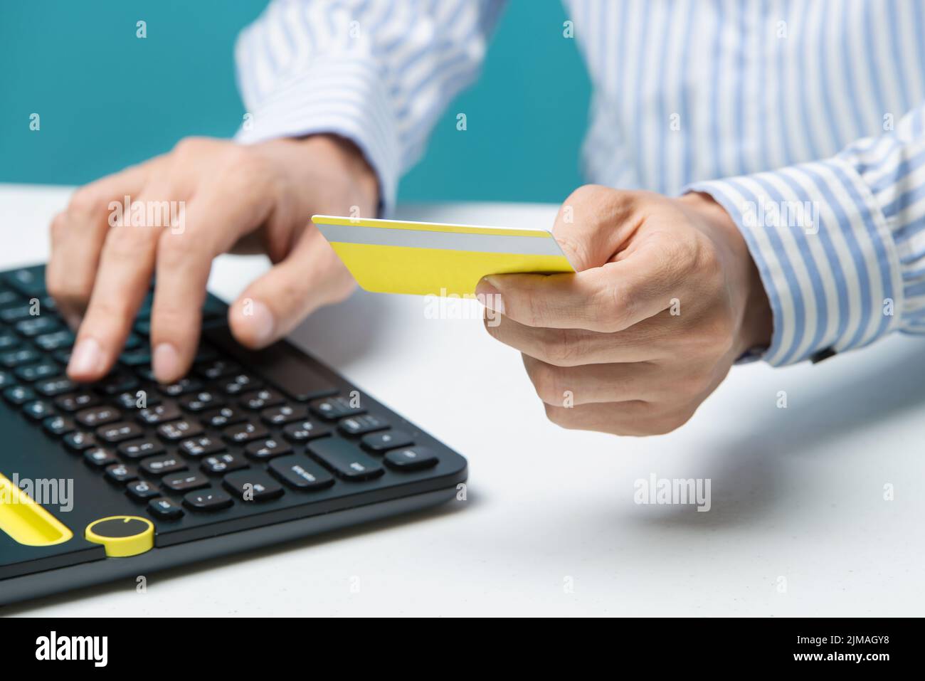 L'uomo usa la tastiera e tiene la carta di credito con i social media come concetto di shopping online Foto Stock