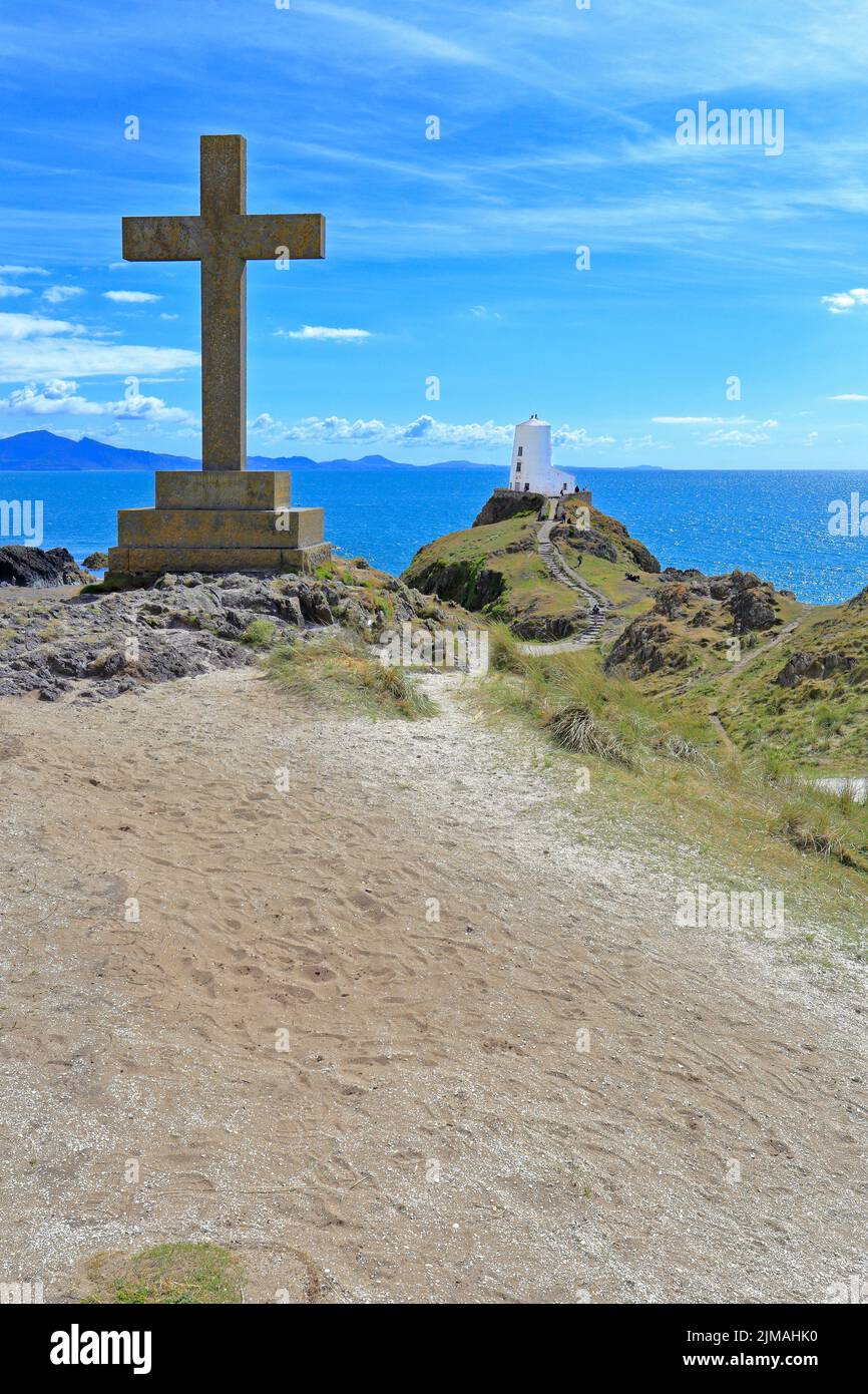 Plain Cross e lontano Twr Mawr, grande torre sull'isola di Llanddwyn, Ynys LLanddwyn, Isola di Anglesey, Ynys Mon, Galles del Nord, REGNO UNITO. Foto Stock