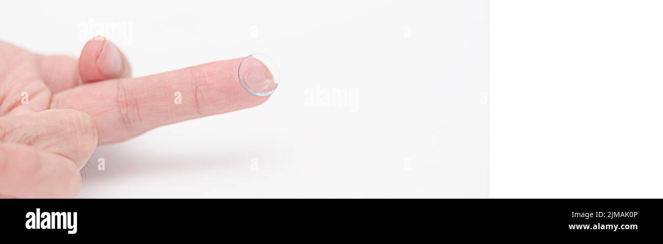 Lente a contatto su dito su sfondo bianco.procedura quotidiana di messa su lenti Foto Stock