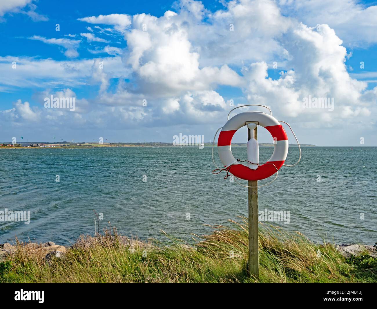 Vista di un anello di salvataggio rosso e bianco sulla riva di Nisum Bredning vicino Agger Havn, Danimarca Foto Stock