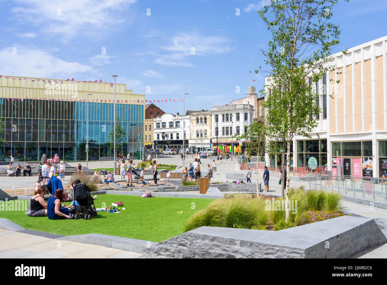 Barnsley Library o la Lightbox persone che godono il sole nella piazza del lavoro di vetro Barnsley South Yorkshire West Riding of Yorkshire Inghilterra UK GB Europe Foto Stock