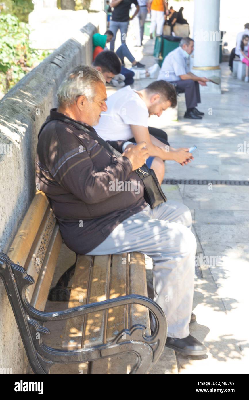 Un uomo seduto su una panchina e riposante Uskudar Istanbul, turchia Foto Stock