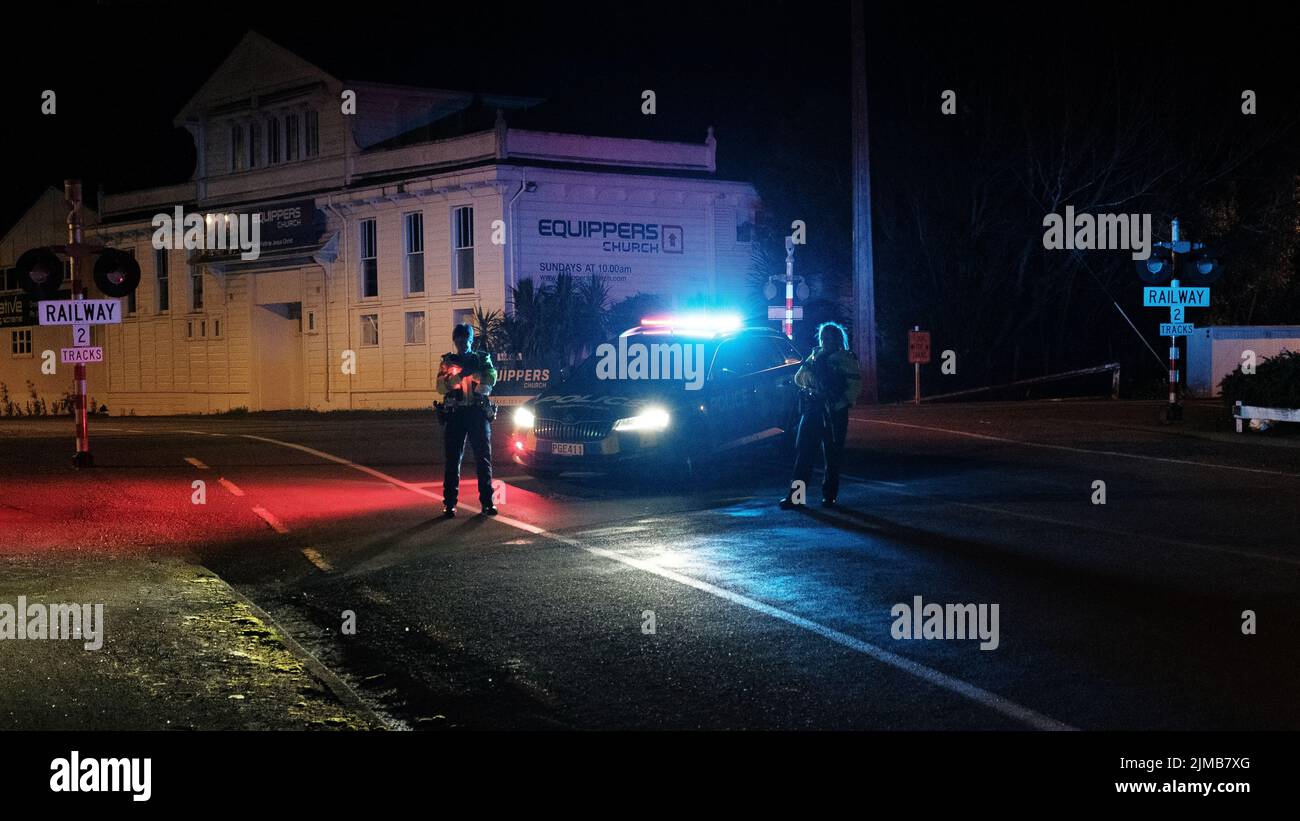 A nite view of New Zealand Police tenere un blocco stradale durante un raid. Foto Stock