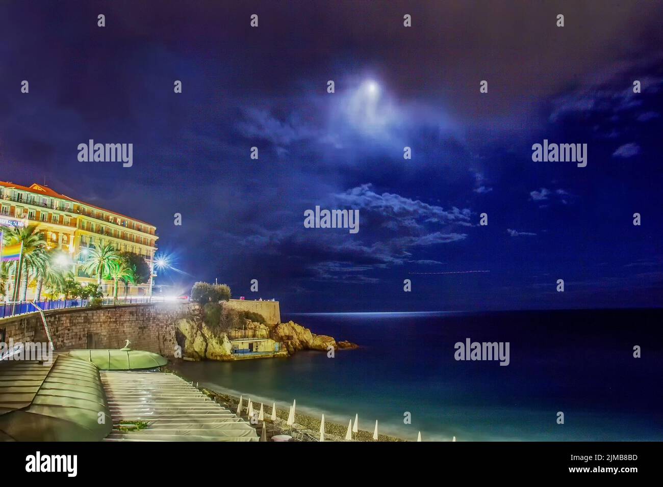 Fantastica vista notturna sullo splendido Mar Mediterraneo e parte dell'edificio (forse SwissNice Hotel) con Luna e nuvole e il lungomare di Rob Kape - e. Foto Stock