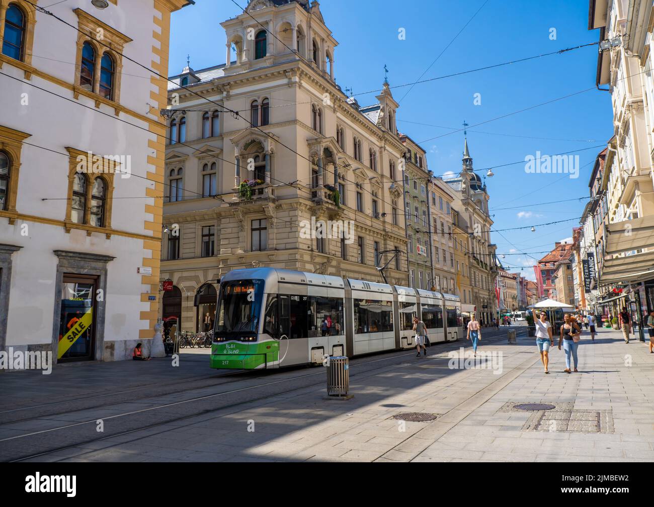 Un tram e persone su una strada principale nel centro della città di Graz, Austria Foto Stock