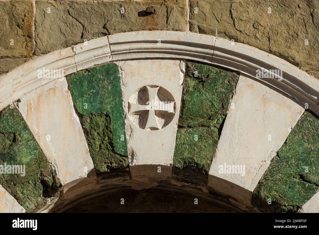 Antica croce sull'edificio medievale di Lucca come sfondo religioso Foto Stock