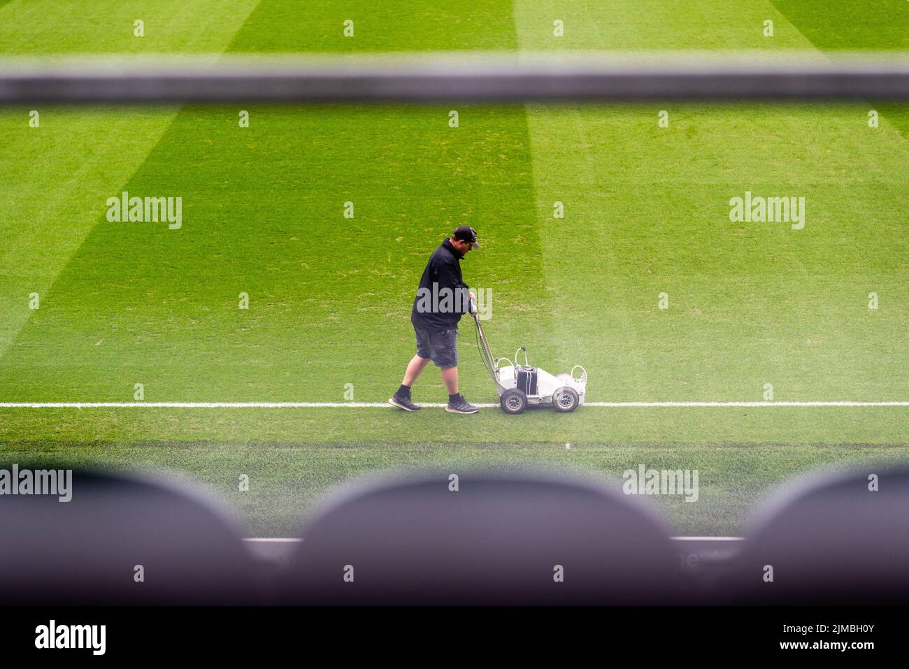 Un Groundman in un campo da calcio dipinge con un pittore di linea, l'Home Park Football Stadium, Plymouth, Devon, Regno Unito Foto Stock